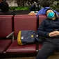 Pelancong memakai masker saat tidur siang di Bandara Internasional Ibu Kota Beijing, 23 Januari 2020. China pada Kamis (23/1) menutup sebuah kota berpenduduk lebih dari 11 juta orang dalam upaya memerangi wabah virus corona, tindakan yang belum pernah terjadi sebelumnya.  (AP/Mark Schiefelbein)