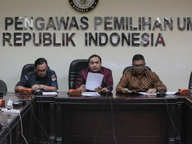 Anggota Bawaslu Muchamad Afifudin (tengah) dan Fritz Siregar menyampaikan temuan dari hasil pengawasan selama tahap pendaftaran dan verifikasi partai politik calon peserta pemilu 2019 di Bawaslu, Jakarta, Selasa (17/10). (Liputan6.com/Faizal Fanani)