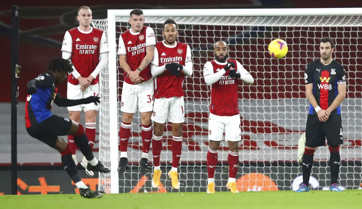Pemain Crystal Palace Eberechi Eze (kiri) melakukan tendangan bebas saat melawan Arsenal pada pertandingan Liga Inggris di Emirates Stadium, London, Inggris, Kamis (14/1/2021). Pertandingan berakhir imbang 0-0. (Julian Finney/Pool via AP)