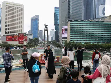 Aktivitas warga di Anjungan Halte Transjakarta Bundaran Hotel Indonesia Astra, Jakarta, Senin (27/1/2025). (Liputan6.com/Angga Yuniar)