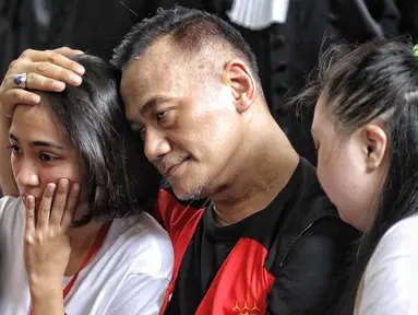 Aktor Tio Pakusadewo merangkul sang anak, Risa (kiri) dan keponakannya, Namira saat menunggu sidang  kasus penyalahgunaan narkoba di Pengadilan Negeri Jakarta Selatan, Kamis (28/6). Sidang beragenda pembacaan pledoi oleh Tio. (Liputan6.com/Faizal Fanani)