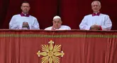 Paus Fransiskus (tengah) saat berada di balkon utama Basilika Santo Petrus sebelum menyampaikan pesan Urbi et Orbi atau kepada kota (Roma) dan dunia sebagai bagian dari perayaan Paskah, di alun-alun Santo Petrus di Vatikan pada tanggal 20 April 2025. (Andreas SOLARO/AFP)