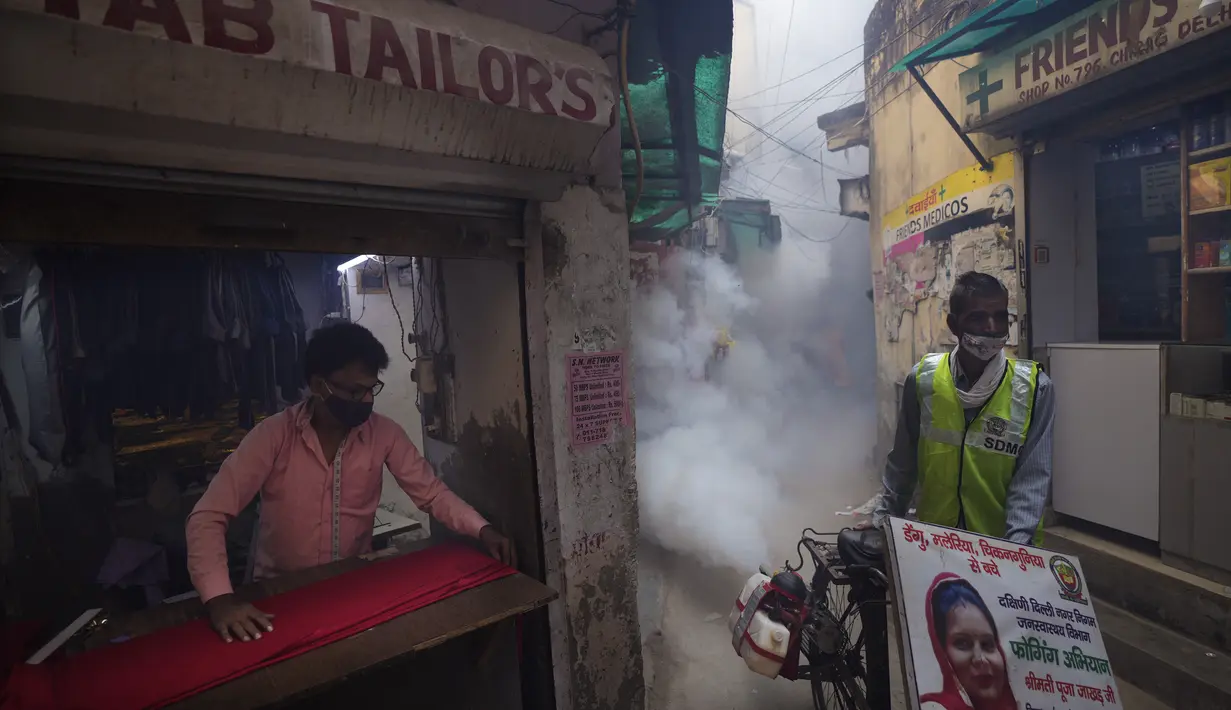 Pekerja kota melakukan fogging atau pengasapan daerah padat penduduk di New Delhi, India, Rabu (27/10/2021). New Delhi telah melaporkan ratusan kasus demam berdarah, dengan lebih dari 200 kasus baru dalam seminggu terakhir, menurut laporan yang dirilis pada hari Senin. (AP Photo/Manish Swarup)