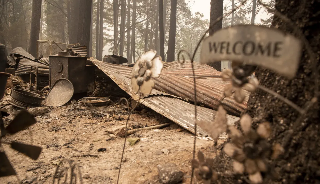 Sebuah rumah yang terbakar membara selama kebakaran Dixie di lingkungan Indian Falls di Plumas County, California (26/7/2021). (AFP/Robyn Beck)