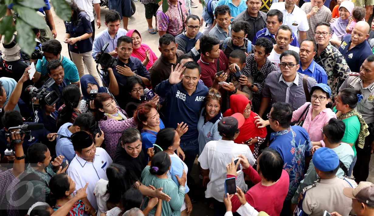 Bakal Calon Gubernur DKI, Agus Harimurti Yudhoyono melambaikan tangan ke arah awak media saat mengunjungi kawasan Bukit Duri, Jakarta, Kamis (20/10). Kunjungan Agus untuk melihat langsung kondisi warga yang terkena gusuran (Liputan6.com/Gempur M Surya)