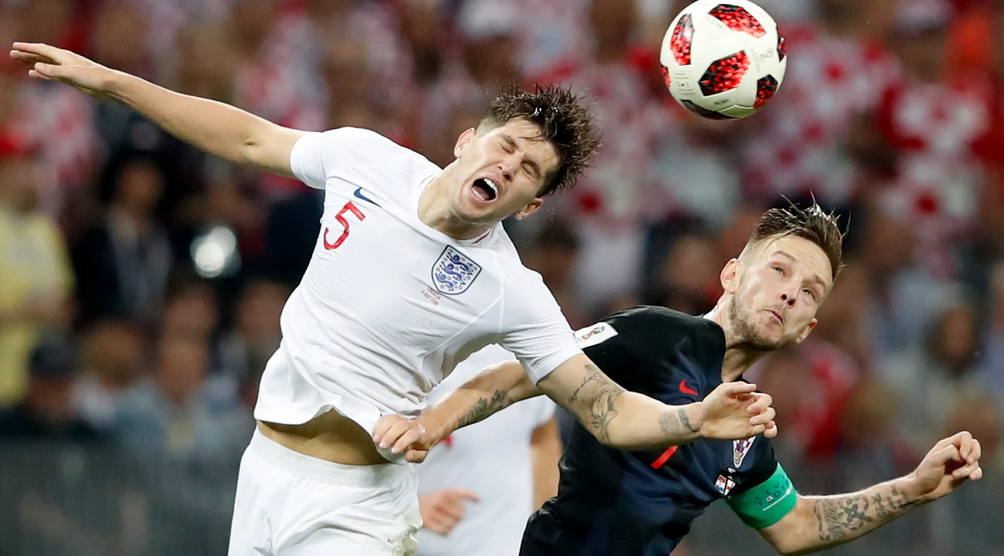 Pemain timnas Inggris, John Stones berebut bola dengan pemain Kroasia, Ivan Perisic pada babak semifinal Piala Dunia 2018 di Stadion Luzhniki, Rabu (11/7). Kroasia akan menantang Prancis di final setelah menang 2-1 atas Inggris. (AP/Rebecca Blackwell)