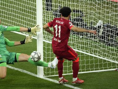 Kiper Real Madrid, Thibaut Courtois, (kiri) melakukan penyelamatan di depan pemain Liverpool, Mohamed Salah saat laga final Liga Champions antara Liverpool melawan Real Madrid yang berlangsung di Stade de France, Saint Denis, Sabtu, 28 Mei 2022 waktu setempat. (AP/Christophe Ena)