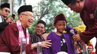 Mantan Ketua Ikatan Pencak Silat Seluruh Indonesia (IPSI), Eddie Nalapraya (berkalungkan kain) saat berbincang seorang pesilat cilik. (Foto: Benedikta Desideria)