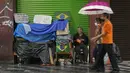Seorang tunawisma makan di samping barang-barangnya di trotoar di pusat kota Sao Paulo, Brasil pada 26 Januari 2022. Sensus baru menunjukkan populasi tunawisma di Sao Paulo telah meningkat 30% selama pandemi COVID-19. (AP Photo/Andre Penner)