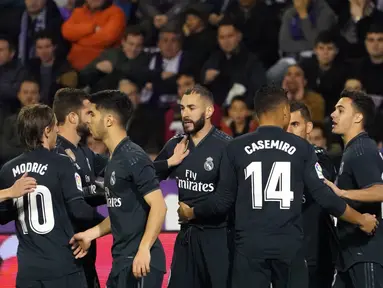 Striker Real Madrid, Karim Benzema berselebrasi usai mencetak gol ke gawang Real Valladolid selama pertandingan lanjutan La Liga Spanyol di stadion Jose Zorrilla,Valladolid (10/3). Benzema mencetak dua gol dipertanding tersebut.  (AFP Photo/Cesar Manso)