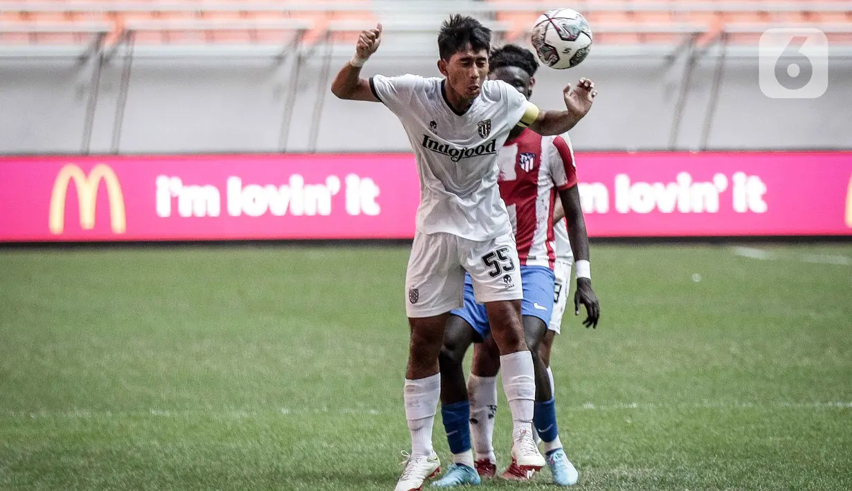 Pemain Bali United U-18 I Made Tito Wiratama berebut bola dengan pemain Atletico Madrid U-18  pada laga perdana International Youth Championship (IYC) 2021 di Jakarta International Stadium (JIS), Rabu (13/4/2022). Atletico Madrid U-18 menang dengan skor 5-0. (Liputan6.com/Faizal Fanani)