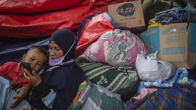 <span>Warga terdampak letusan gunung Semeru mengungsi di tempat penampungan sementara di desa Sumber Wuluh di Lumajang, Jawa Timur, Senin (6/12/2021). Berdasarkan laporan Posko Tanggap Darurat Bencana Gunung Semeru erupsi, total korban jiwa ada sebanyak 15 orang meninggal dunia. (Juni Kriswanto/AFP)</span>