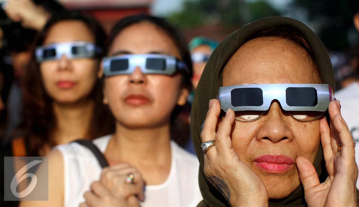 Warga mengunakan kacamata khusus menyaksikan proses Gerhana Matahari Total (GMT) 2016 di halaman Taman Ismail Marzuki (TIM), Jakarta, Rabu (9/3). Di Jakarta, gerhana matahari terjadi sebesar 88,76 persen selama sekitar 2. (Liputan6.com/Fery Pradolo)