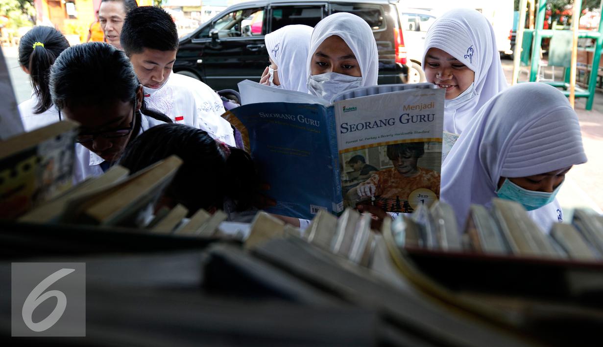 <p>Sejumlah siswa membaca buku dari mobil perpustakaan keliling di halaman sekolah, Jakarta, Jumat (4/9/2015). Sebelumnya sekolah SMPN 49 mengalami kebakaran dan menyebakan ruangkan perpustakaan ludes terbakar. (Liputan6.com/Yoppy Renato)</p>