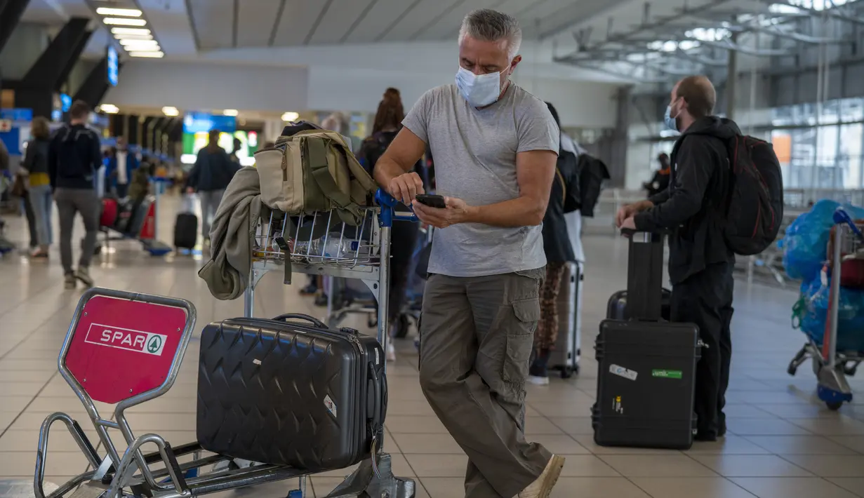Orang-orang berbaris untuk dites Covid-19 di bandara OR Tambo di Johannesburg, Jumat (26/11/2021). Sejumlah negara menghentikan perjalanan udara dari Afrika Selatan terkait kemunculan varian baru COVID-19 yang berpotensi lebih menular yang telah terdeteksi di Afrika Selatan. (AP/Jerome Delay)