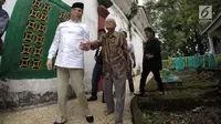 Saifudin Aswari menggandeng seorang kakek saat ziarah ke makam Sultan Mahmud Badaruddin di Palembang, Sumsel, Jumat (26/1). Aswari menggandeng Wali Kota Pangkalpinang M Irwansyah sebagai pasangan bakal calon Pilkada Sumsel 2018. (Liputan6.com/Aswari)