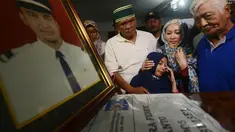 Istri (kedua kanan) dan anak menyambut kedatangan jenazah Yudhistira Febbi Arianto, co pilot pesawat Aviastar di masjid dekat Bandara Ngurah rai, Bali, Kamis (8/10). Pesawat Aviastar jatuh dan menewaskan 3 kru dan 7 penumpang. (AFP PHOTO/SONNY TUMBELAKA)