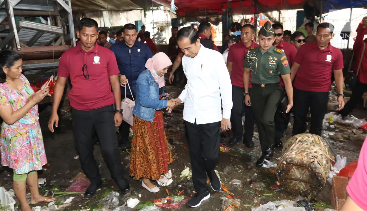Presiden Joko Widodo atau Jokowi menyalami warga saat blusukan di Pasar Minggu, Jakarta, Jumat (22/2). Jokowi mengenakan kemeja putih lengan panjang, celana hitam, dan sepatu sneakers. (Liputan6.com/Angga Yuniar)