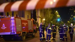 Petugas pemadam tiba di lokasi serangan bom yang menghantam sebuah kantor cabang bank asal Yunani, Eurobank, di pusat Kota Athena, Rabu (19/4). Seorang tak dikenal sempat memberi peringatan melalui telepon kepada situs Zougla. (LOUISA GOULIAMAKI/AFP)