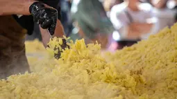 Koki memasak rosti dalam upaya memecahkan rekor dunia saat acara yang menandai peringatan 125 tahun Serikat Petani Swiss (SBV) di Bern, Swiss pada 19 September 2022. Sebagian dari rosti itu kemudian dibagikan kepada warga yang menonton acara itu. (Fabrice COFFRINI / AFP)