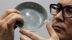 Staf Balai Lelang Sotheby menunjukkan mangkuk berusia 1.000 tahun dari Dinasti Song di Hong Kong, Selasa (3/10). Terjual sekitar Rp510,4 miliar, mangkuk berdiameter 13 cm itu memecahkan rekor lelang dunia untuk barang-barang keramik China. (AP/Kin Cheung)