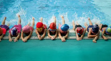 Sejumlah anak melakukan pemanasan sebelum latihan berenang di sekolah Hangzhou Chen Jinglun Sport sekolah Natatorium, Hangzhou, provinsi Zhejiang, China, (10/8). Sekolah ini pernah melatih perenang Olimpiade Sun Yang dan Fu Yuanhui. (REUTERS/Aly Song)