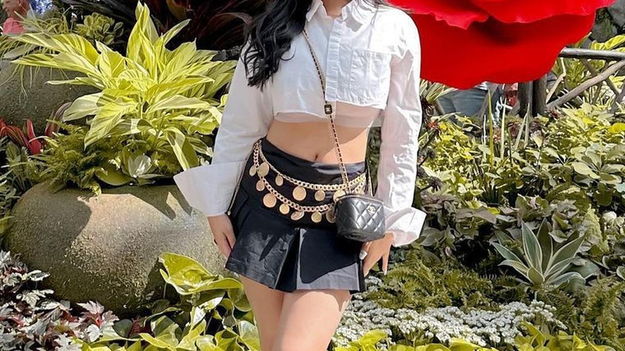 Pada saat jalan-jalan, outfit Rachel juga cukup stylish dan meriah. Ia menambahkan aksesoris pinggul saat mengenakan rok mini berwarna hitam disertai kemeja crop top.