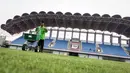 Pekerja sedang melakukan pemupukan rumput di Stadion Indomilk Arena, Tangerang pada Rabu (25/08/2021) sore WIB. Hal tersebut merupakan salah satu bentuk perawatan dan persiapan stadion untuk menyambut kompetisi BRI Liga 1 yang akan segera bergulir. (Foto: Bola.com/Bagaskara Lazuardi)