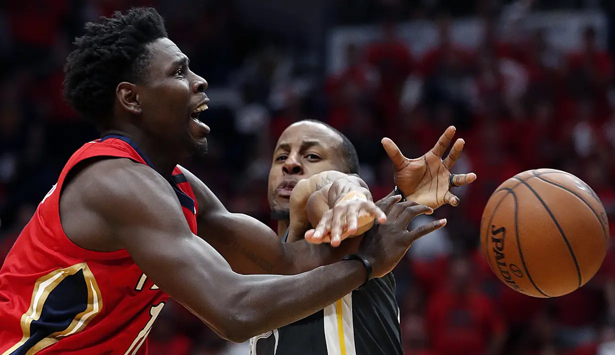 Aksi pemain Pelicans, Jrue Holiday (kiri) berebut bola dengan pemain Warriors, Andre Iguodala pada laga gim ketiga semifinal NBA basketball playoff di Smoothie King Center, New Orleans, (4/5/2018). Pelicans menang 119-100. (AP/Gerald Herbert)