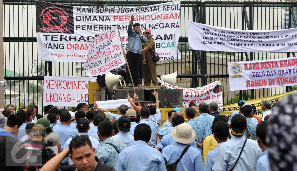 Ribuan Supir Taksi melakukan demo di depan Gedung DPR/MPR, Jakarta, Selasa (22/3). Selain melakukan demo, supir taksi tersebut melakukan sweeping ke supir taksi yang beroperasi di dalam tol dan membakar ban. (Liputan6.com/Johan Tallo)