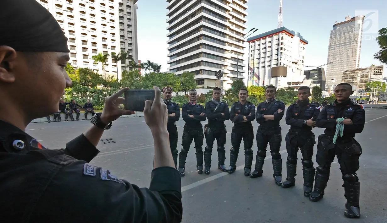 Sejumlah Korps Brimob berfoto disela penjagaan mereka di kawasan MH Thamrin, Jakarta, Jumat (24/5/2019). Usai kerusuhan 22 Mei 2019, penjagaan di kawasan jalan MH Thamrin sampai Jumat, 24 Mei 2019 masih terus dilakukan oleh aparat kepolisian. (Liputan6.com/Herman Zakharia)
