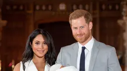 Pangeran Harry dan Meghan Markle berpose  dengan bayi laki-lakinya yang baru lahir di St George's Hall di Windsor Castle di Windsor, London (8/5/2019). Pangeran Harry dan Meghan Markle melahirkan anak pertama mereka di Frogmore Cottage pada Senin pagi, 6 Mei 2019.  (AFP Photo/Dominic Lipinski)