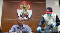 Ketua KPK Agus Rahardjo (kiri) melihat barang bukti hasil OTT Bupati Pakpak Bharat Sumatera Utara, Remigo Yolanda Berutu di Gedung KPK, Jakarta, Minggu (18/11). KPK menetapkan tiga tersangka dan menyita uang Rp 150 juta. (Liputan6.com/Helmi Fithriansyah)