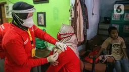Petugas medis menyuntikan vaksin Covid-19 kepada warga saat vaksinasi Covid-19 secara door to door di kawasan Bogor, Jawa Barat, Rabu (14/7/2021). Metode vaksinasi yang digunakan BIN mengadopsi metode vaksinasi door to door yang digunakan beberapa negara. (Liputan6.com/Faizal Fanani)