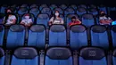 Orang-orang menikmati film di bioskop yang dibuka kembali menyusul pelonggaran langkah-langkah yang diberlakukan oleh pemerintah Kolombia untuk menghentikan penyebaran Covid-19, di Cali, Kolombia pada Jumat (2/10/2020). (Photo by Luis ROBAYO / AFP)