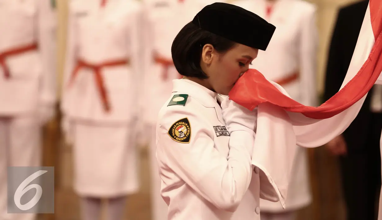 Anggota paskibraka 2016 mencium bendera merah putih saat Upacara Pengukuhan Paskibraka di Jakarta, Senin (15/8). Sebanyak 68 paskibraka dikukuhkan oleh Presiden yang telah melewati seleksi dari seluruh daerah di Indonesia. (Liputan6.com/Faizal Fanani)