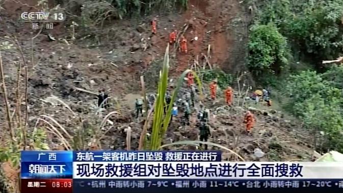 Tim penyelamat dan tentara melakukan operasi pencarian di lokasi kecelakaan pesawat maskapai China Eastern Airline di Tengxian, Daerah Otonomi Guangxi Zhuang, Selasa (22/3/2022). Barang yang ditemukan ada berupa dompet serta tanda pengenal di area kecelakaan pesawat. (CCTV via AP Video)