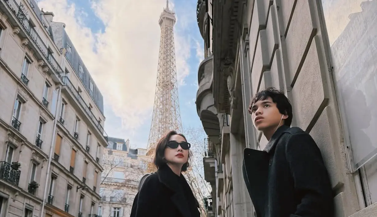Berlatar Menara Eiffel, Bunga Citra Lestari foto bareng Noah dengan setelan long coat hitam [@itsmebcl]