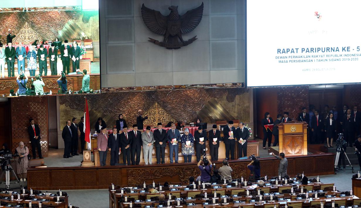 Ketua DPR Bambang Soesatyo (enam kiri) didampingi pimpinan DPR lainnya memberikan buku laporan kinerja DPR dalam Rapat Paripurna di Kompleks Parlemen, Jakarta, Kamis (29/8/2019). Rapat Paripurna beragendakan pidato Ketua DPR Bambang Soesatyo dalam rangka HUT ke-74 DPR. (Liputan6.com/JohanTallo)