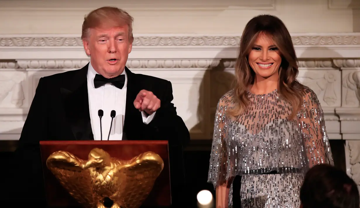 Presiden AS, Donald Trump dan Melania Trump memberikan sambutan pada jamuan makan malam White House Historical Association, Jumat (15/9). First Lady Amerika Serikat itu memadukan gaunnya dengan ikat pinggang dan perhiasan minimalis. (NICHOLAS KAMM / AFP)