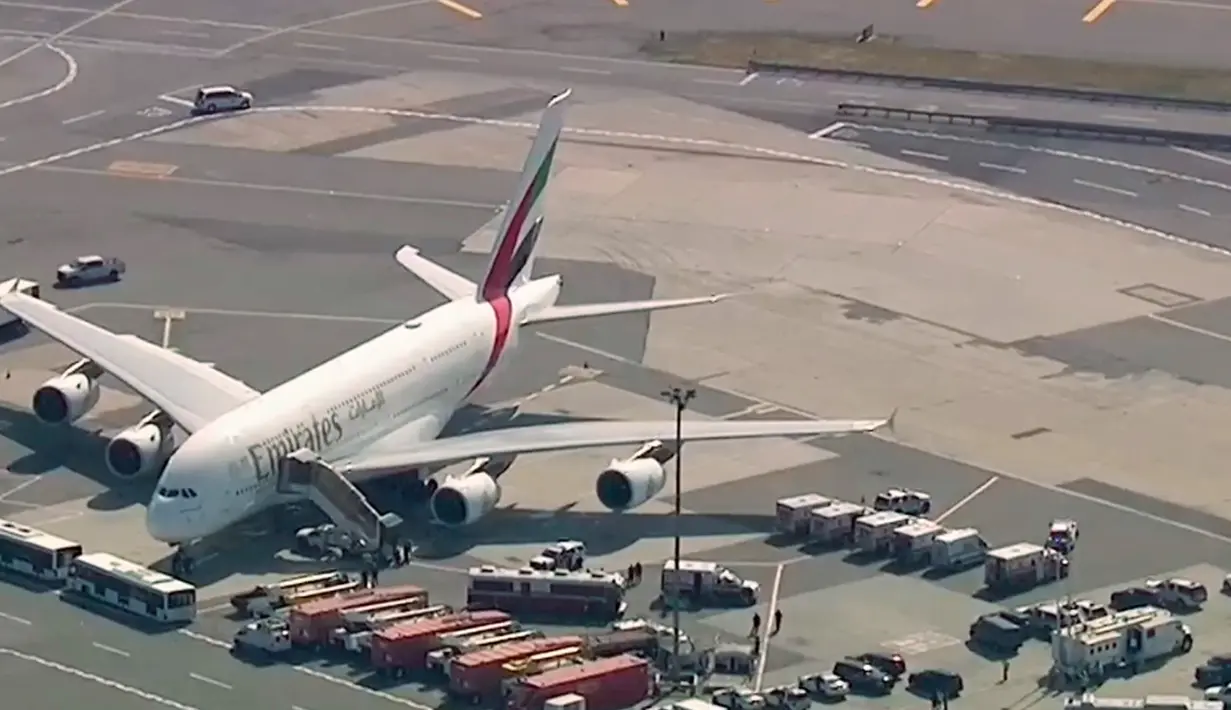 <p>Petugas tanggap darurat berkumpul di luar pesawat setelah sekitar 100 penumpang Emirates Airline dilaporkan sakit di Bandara Kennedy New York, Rabu (5/9). Pesawat dari Dubai ke New York itu dikarantina dan dipantau polisi kontra-terorisme. (WABC 7 via AP)</p>