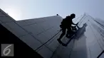 Pekerja membersihkan kaca gedung bertingkat di Jakarta, Senin (25/8/2015). Untuk meminimkan kecelakaan, Kementerian Tenaga Kerja dan Transmigrasi telah mencanangkan bulan Keselamatan dan Kesehatan Kerja (K3) pada tahun 2014. (Liputan6.com/Helmi Afandi)