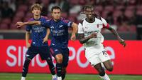 Rafael Leao (kanan) dari AC Milan dan Martin Zubimendi (tengah) dari Arsenal berebut bola dalam pertandingan persahabatan di Singapore Festival of Football yang diadakan di National Stadium, Singapura, Rabu, 23 Juli 2025. (AP Photo/Vincent Thian)