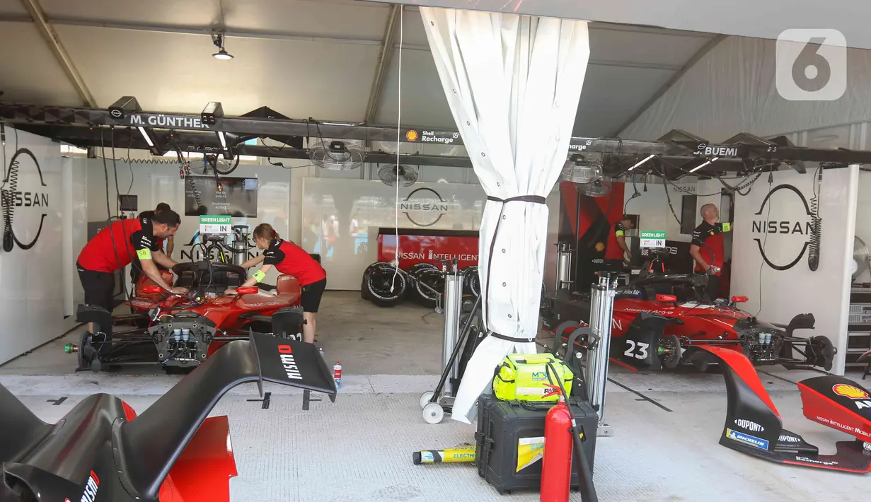 Kru tim peserta lomba balap melakukan persiapan mobil listrik Formula E  di pit Jakarta International E-Prix Circuit (JIEC), Jakarta, Jumat (3/6/2022). Menjelang pertandingan Formula E pada besok hari (4/6/2022) kru tim pembalap melakukan persiapan mobil listrik Formula E. (Liputan6.com/Herman Zakharia)