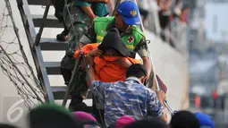 Petugas membantu warga eks Gafatar saat turun dari KRI Teluk Bone 551 di Pelabuhan Tanjung Priok, Jakarta, Kamis (28/1/2016). Sebanyak 824 warga eks Gafatar dipulangkan dari Kalimantan untuk dikembalikan ke daerah asal. (Liputan6.com/Gempur M Surya)
