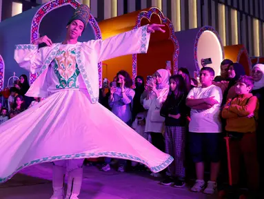 Orang-orang merayakan festival Garangao, sebuah pesta tradisional anak-anak di kawasan Teluk yang dirayakan setelah berbuka puasa di Doha pada 24 Maret 2024. (KARIM JAAFAR/AFP)