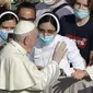 Paus Fransiskus menyapa umatnya yang memakai masker untuk mencegah penyebaran COVID-19 saat ia tiba di halaman St. Damaso pada kesempatan audiensi umum mingguannya di Vatikan, Rabu (16/9/2020). (AP Photo/Gregorio Borgia)