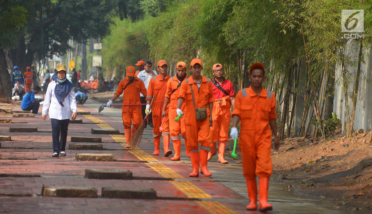 Petugas PPSU bersiap membersihkan trotoar di Jalan Asia Afrika, Jakarta, Kamis (2/8). Trotoar yang di pakai para pedagang kaki lima ini di bersihkan guna jelang Asian Games 2018 di Jakarta dan Palembang. (Merdeka.com/Imam Buhori)