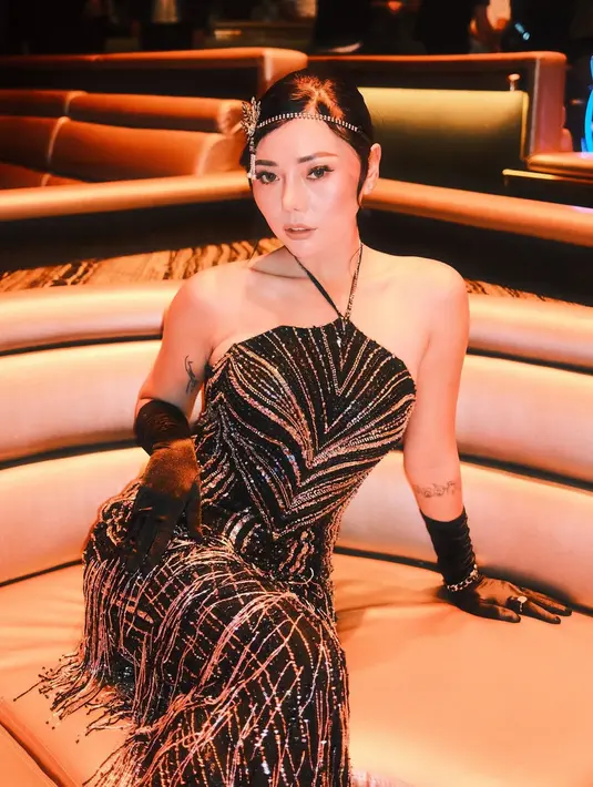 Wendy Walter kenakan halter strap dress dengan full payet kristal dan fringe yang glamor. Dipadu dengan gloves hitam dan headpiece minimalis yang statement [@wendywalters]