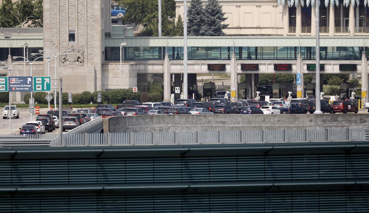Mobil-mobil menunggu untuk memasuki bea cukai Kanada di Rainbow Bridge, Niagara Falls, New York, Amerika Serikat, Senin (9/8/2021). Kanada mencabut larangan terhadap warga AS yang melintasi perbatasan untuk berbelanja, berlibur, atau berkunjung ke negaranya. (Derek Gee/The Buffalo News via AP)
